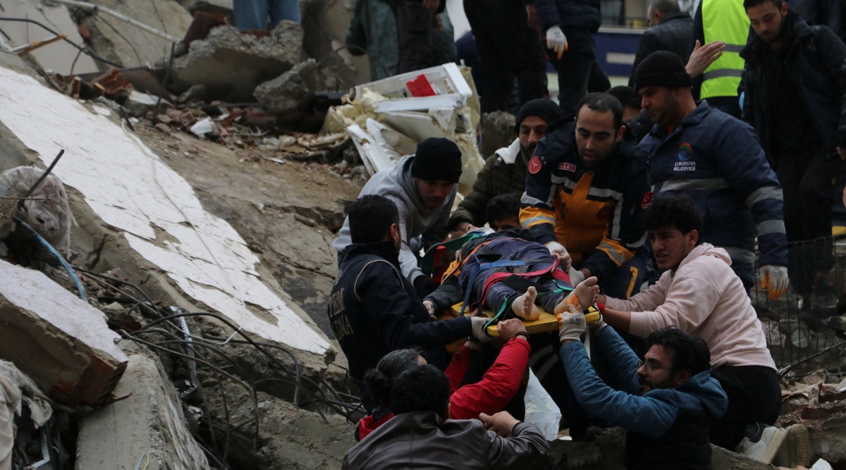 Rescuers carry out a person from a collapsed building after an earthquake in Adana, Turkey (Reuters)