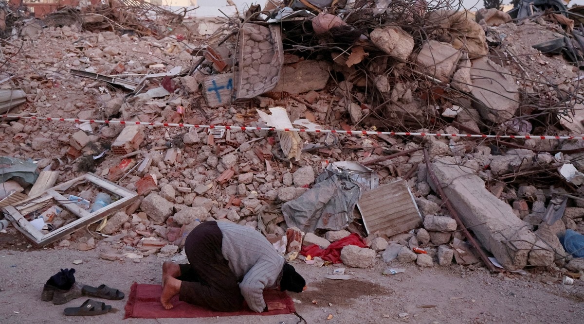 A man prays near the rubble of destroyed homes, in the aftermath of a deadly earthquake in Kahramanmaras, Turkey, February 14, 2023. (Reuters)