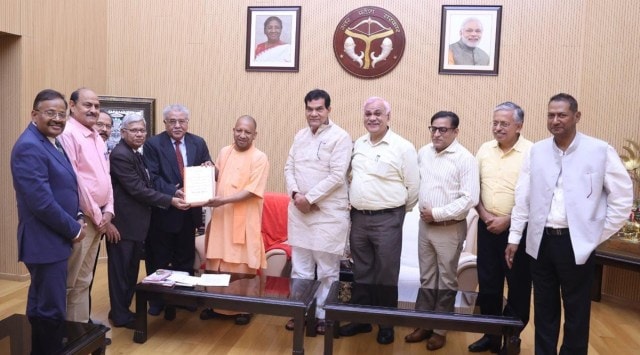 CM Yogi Adityanath receives the report from the panel members, Thursday. (Express Photo)