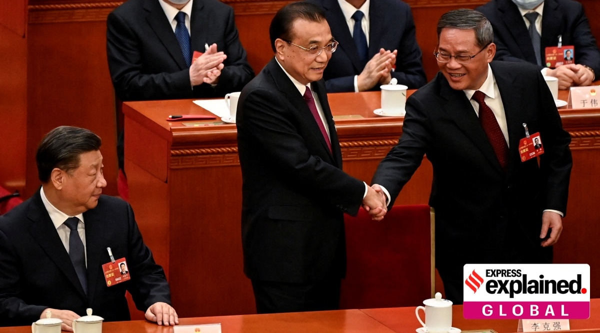 China's former Premier Li Keqiang (C) shakes hands with newly elected Premier Li Qiang (R).