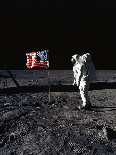Buzz Aldrin posing next to the American flag on the moon during the Apollo 11 mission. 