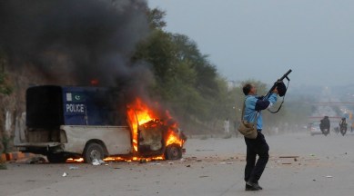 A police officer fires a tear gas canister as supporters of former Pakistani Prime Minister Imran Khan clash with police outside a Federal Court Complex in Islamabad, Pakistan, on March 18, 2023.