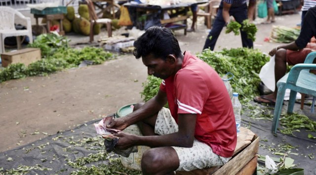 A vendor counts his cash at his stall at a main market, after The International Monetary Fund's executive board approved a $3 billion, in Colombo, Sri Lanka March 21, 2023.