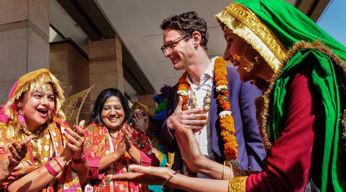 Students wearing traditional dresses welcome G20 delegates in Amritsar, Tuesday. (PTI Photo)