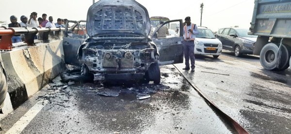 Police and fire department officials put out the fire from the Toyota Fortuner car on the Noida-Greater Noida Expressway. (Express photo)