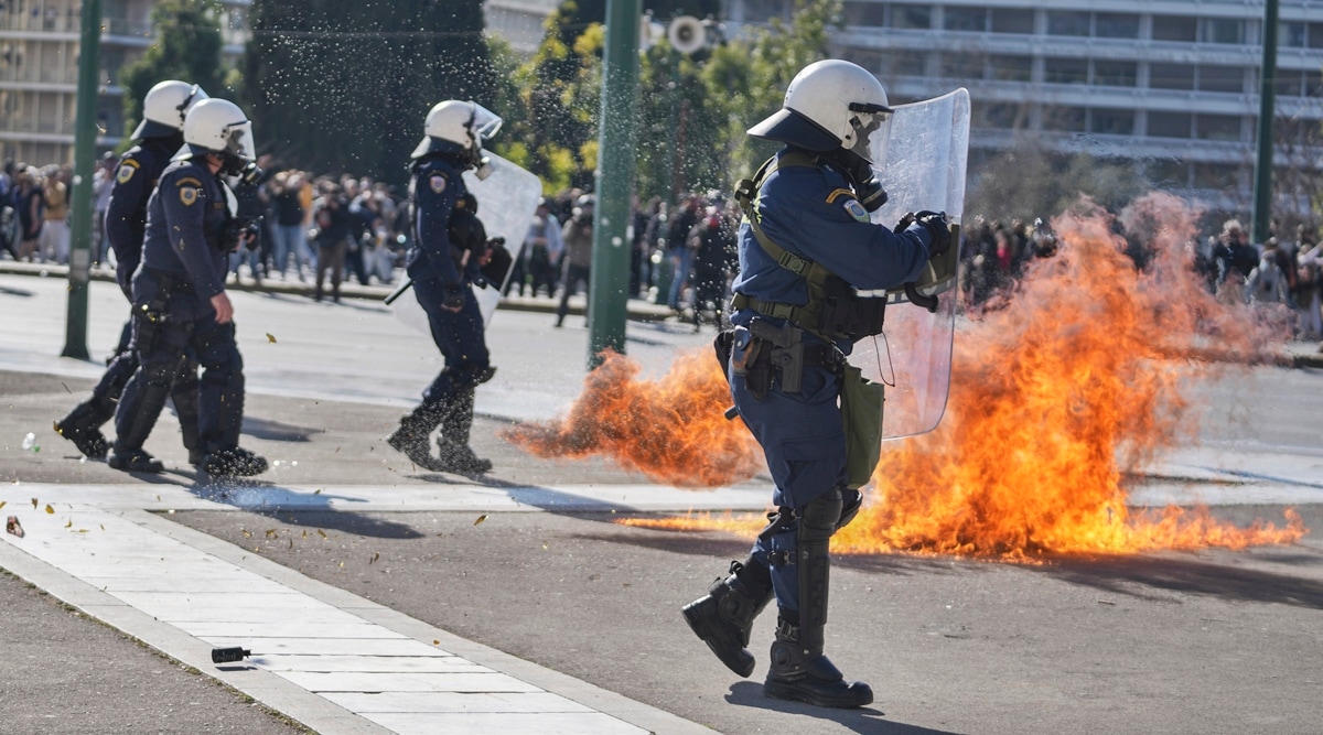 Riot police try to avoid the flames of a molotov cocktail thrown by protesters during a protest for victims of a rail disaster, outside of the Parliament in central Athens, on March 8, 2023. (AP)