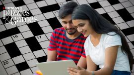 two indian students solve a cryptic crossword on their laptop