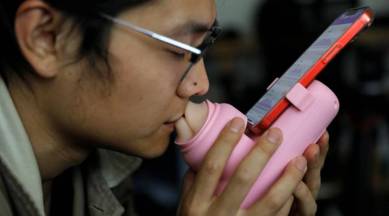 Jing Zhiyuan uses a remote kissing device "Long Lost Touch", as he demonstrates for camera how to use it during an interview with Reuters, at his home in Beijing