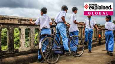 Children in school uniforms on bicycles.