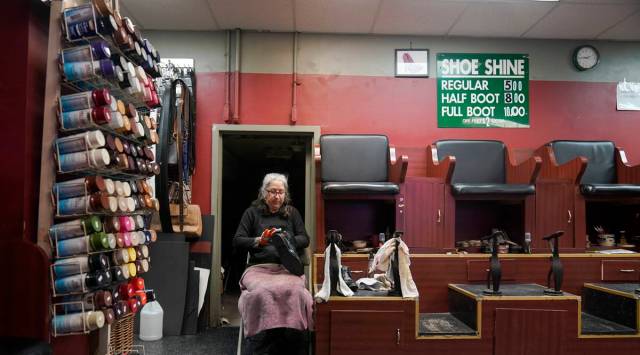 Bertha Gomez shines a shoe while waiting for customers at the Alpha Shoe Repair Corp., Friday, Feb. 3, 2023, in New York. Once a common practice, the tradition of getting a quick polish from a rag-toting shoeshine has become more of a rarity, and many stands have disappeared across the country. (AP Photo/Mary Altaffer)