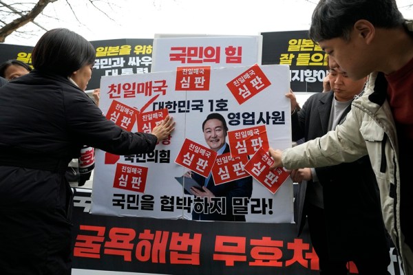 2023 年 3 月 8 日、韓国の高陽で行われた集会で、抗議者たちは韓国のユン ソクヨル大統領の画像にステッカーを貼りました。 
