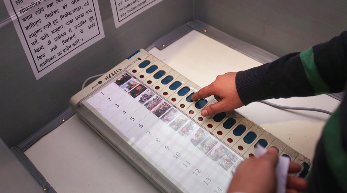 A visitor casts his vote (for a photography competition) using an EVM at a model polling station
