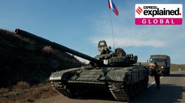 A service member of the Russian peacekeeping troops stands next to a tank near the border with Armenia, following the signing of a deal to end the military conflict between Azerbaijan and ethnic Armenian forces, in the region of Nagorno-Karabakh, November 10, 2020.