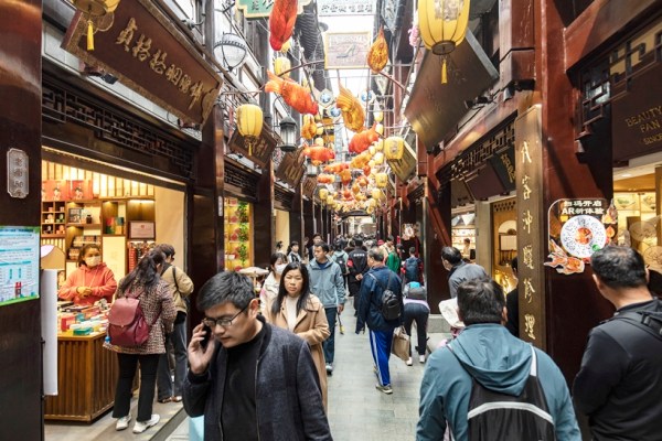 Tourists in the city temple bazaar surrounding the Yuyuan Gardens in Shanghai, on April 07, 2023. Despite loosened visa rules, the number of flights into China is still a small fraction of what it was before the pandemic, fueled partly by geopolitical tensions. (Qilai Shen/The New York Times)