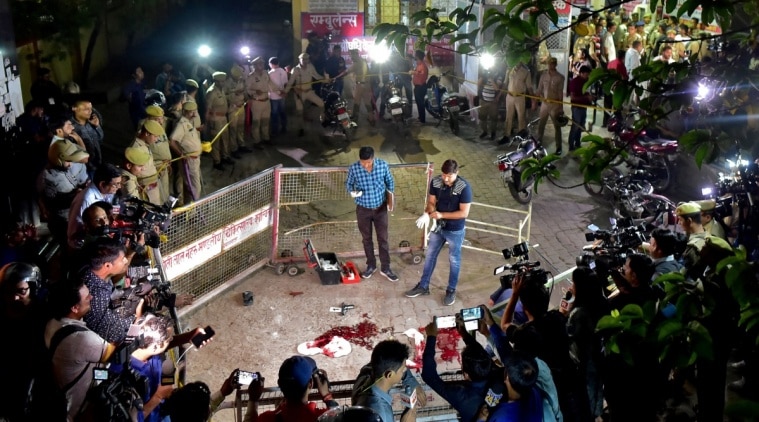 Forensic officials examine the spot where Atiq Ahmed and his brother Ashraf Ahmed were shot dead in Prayagraj