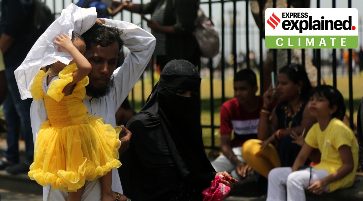 A family tries shielding from the sun through clothes over their heads in Mumbai, Maharashtra.