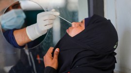 A healthcare worker collects a swab sample of a woman for Covid-19 test, amid a rise in coronavirus cases in the country, in Jammu, April 17, 2023. (PTI)