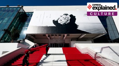 Workers install the red carpet in front of the main entrance of the Festival Palace before the opening ceremony.