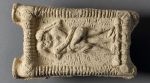 A Babylonian clay model showing a nude couple engaged in kissing.