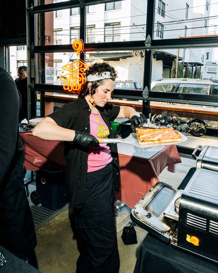 Natalie DeSabato inspects the crust on one of her square pizzas at a Traze pop-up inside Fifth Hammer Brewing in Queens, April 26, 2023. (DeSean McClinton-Holland/The New York Times)