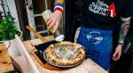 Auggie Russo puts olive oil on a pizza at his Tiny Pizza Kitchen pop-up in Brooklyn, April 25, 2023. (DeSean McClinton-Holland/The New York Times)