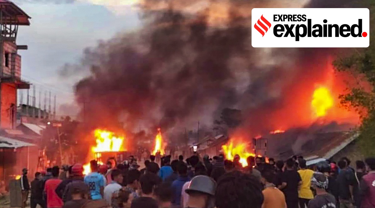 People at the site of a fire incident, with smoke bellowing out, after violence broke out on Wednesday between tribals and non-tribals during 'Tribal Solidarity March' called by All Tribal Student Union Manipur (ATSUM).