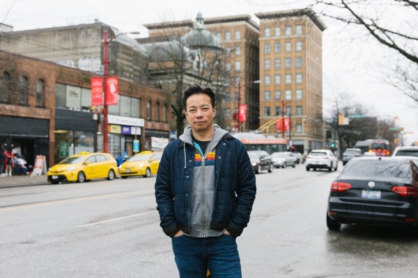 Mayor Ken Sim of Vancouver stands in front of the buildings that his father used to manage when he was a child in Vancouver, B.C., Canada, on April 8, 2023. Sim first ran for mayor in 2018 — and narrowly lost, partly because he was perceived by many as a conservative in a suit; during the 2022 campaign, he wore jeans and T-shirts. (Jackie Dives/The New York Times)