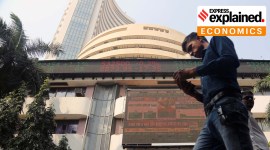 People walk as a telecast of India's Finance Minister Nirmala Sitharaman presenting the budget is displayed inside the Bombay Stock Exchange (BSE) building in Mumbai in 2023. (Express Photo By Ganesh Shirsekar)