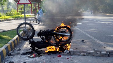 A man watches a burning motorbike set on fire by angry supporters of Pakistan's former Prime Minister Imran Khan during a protest against the arrest of their leader, in Lahore, Pakistan, May 10, 2023. (AP)