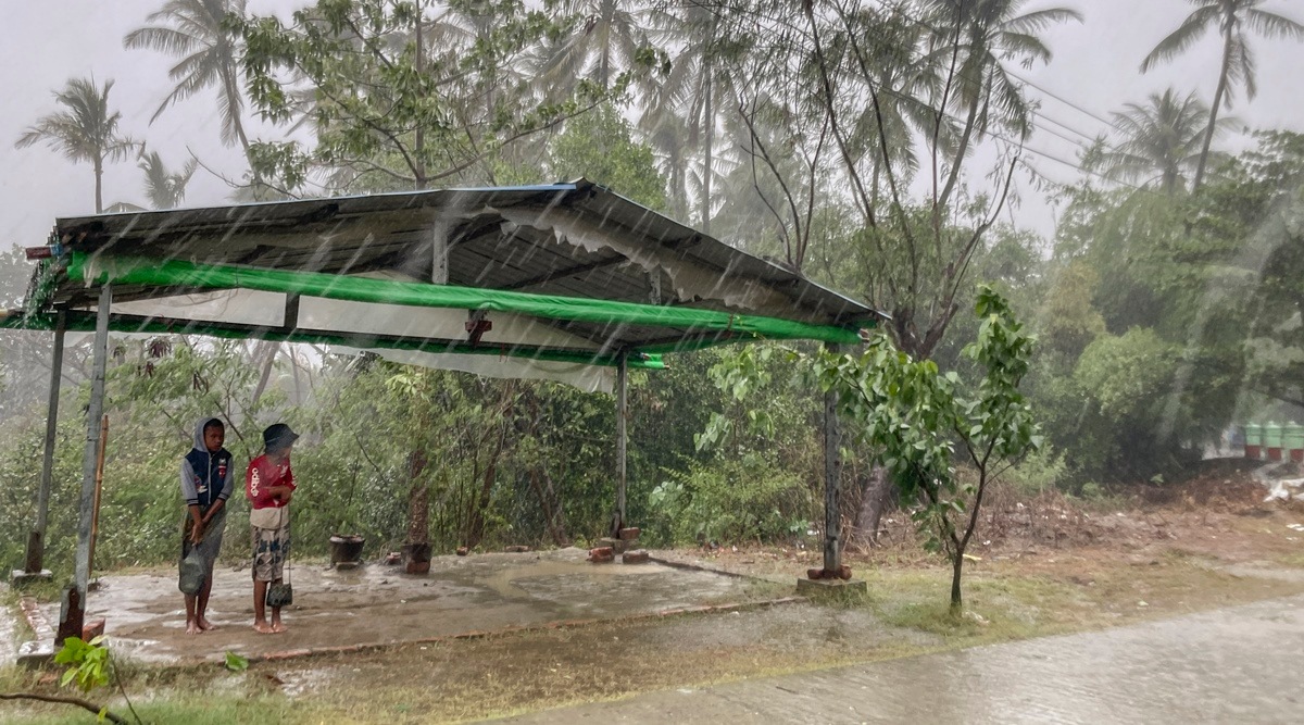 Two children stand under a roadside shelter to protect from rain before Cyclone Mocha hits in Sittwe, Rakhine State. (AP)