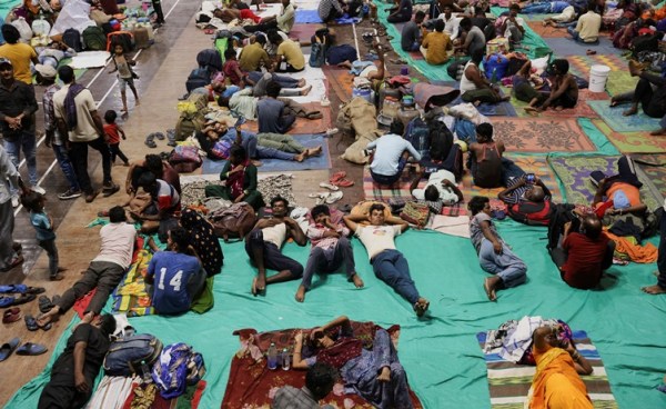 People evacuated from Kandla port are seen inside a port authority multi-purpose hall converted into a shelter, before the arrival of cyclone Biparjoy, in Gandhidham, Gujarat, India, on June 13, 2023.