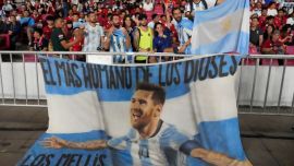 Supporters of Argentina display a flag bearing an image of soccer superstar Lionel Messi.