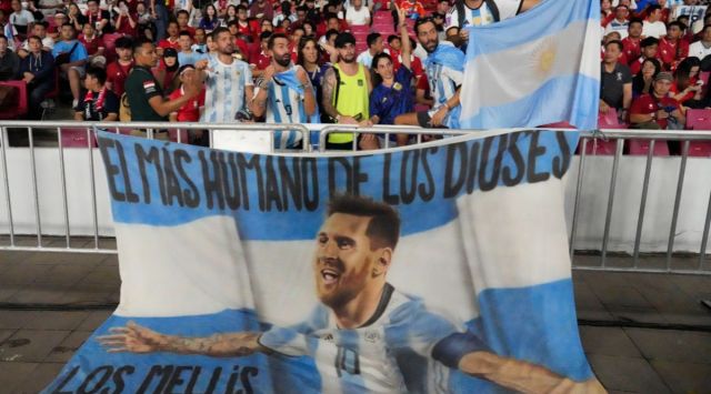 Supporters of Argentina display a flag bearing an image of soccer superstar Lionel Messi.