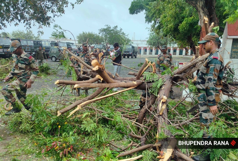 Indian Army jawans remove a tree