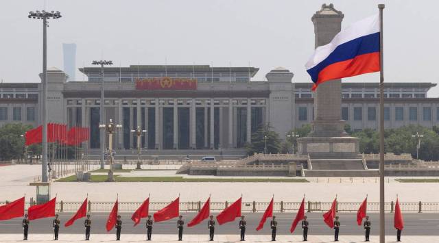 The Russian national flag flies in front of the Great Hall of the People before a welcoming ceremony for Russian Prime Minister Mikhail Mishustin in Beijing