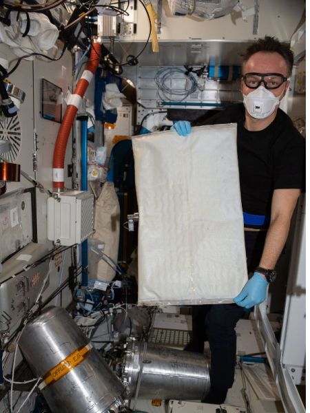 NASA astronaut replacing a bladder on the space station 