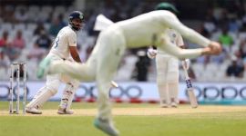 Steve Smith dives to take a catch of India's Virat Kohli