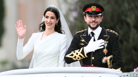 Jordan's Crown Prince Hussein and Saudi Rajwa Alseif wave to well-wishers during their wedding ceremonies in Amman, Jordan, June 1, 2023. (AP)