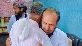 People offer their support to Raja Yousaf, right, whose son Raja Sajid is missing after a shipwreck off the Greek coast, in Bindian village in Kotli, a district of Pakistan-occupied Kashmir, June 18, 2023. (AP)