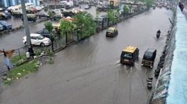 Vehicles wade through a waterlogged road after heavy rain