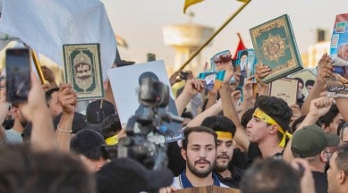 Iraqis raise copies of the Quran during a protest in Tahrir Square, July 20, 2023 in Baghdad, Iraq.