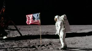 Neil armstrong on the moon next to an american flag