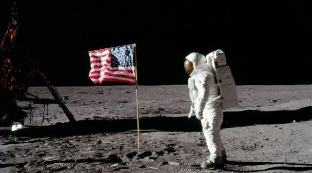 Neil armstrong on the moon next to an american flag