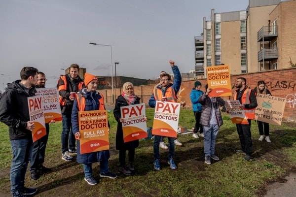 Young doctors sit in protest against higher starting wages outside Queen's Hospital in Romford, England, March 15, 2023. 