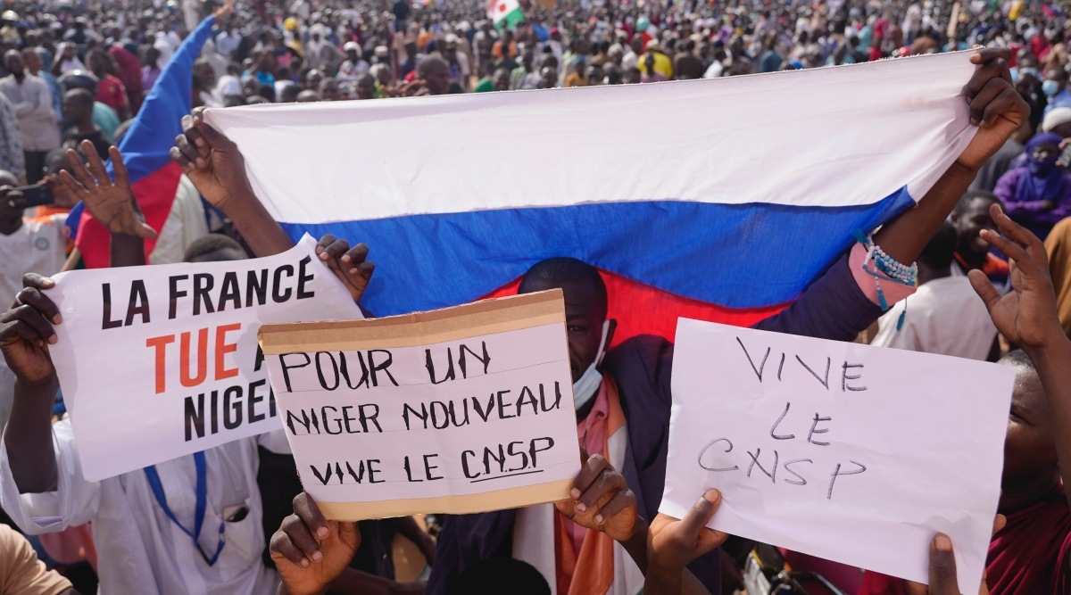 Supporters of Niger’s coup march through the capital waving Russian