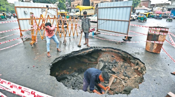 Work in progress at the site where a road caved in near Dariyapur Darwaza in Ahmedabad Sunday.