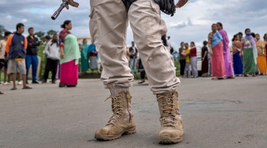 A Manipur policeman stands guard as members of the Meira Paibis, a Hindu-majority Meitei women's group, block traffic to check vehicles belonging to members of the rival tribal Kuki community, in Imphal, Manipur, on June 19, 2023.  (AP)