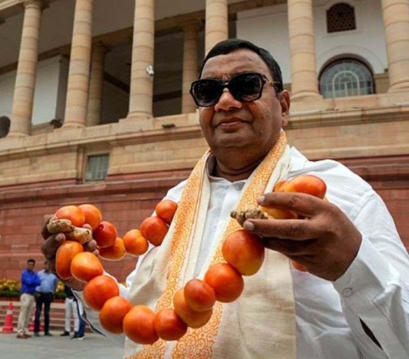 AAP Rajya Sabha MP Dr Sushil Gupta dons a garland of tomatoes and ginger, in a bid to make a statement on rising commodity prices. (PTI photo)
