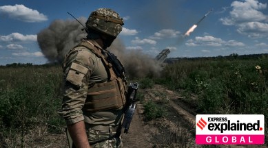 A Ukrainian soldier watches a Grad multiple launch rocket system firing shells with flyers near Bakhmut, Donetsk region, Ukraine, Sunday, Aug. 13, 2023.