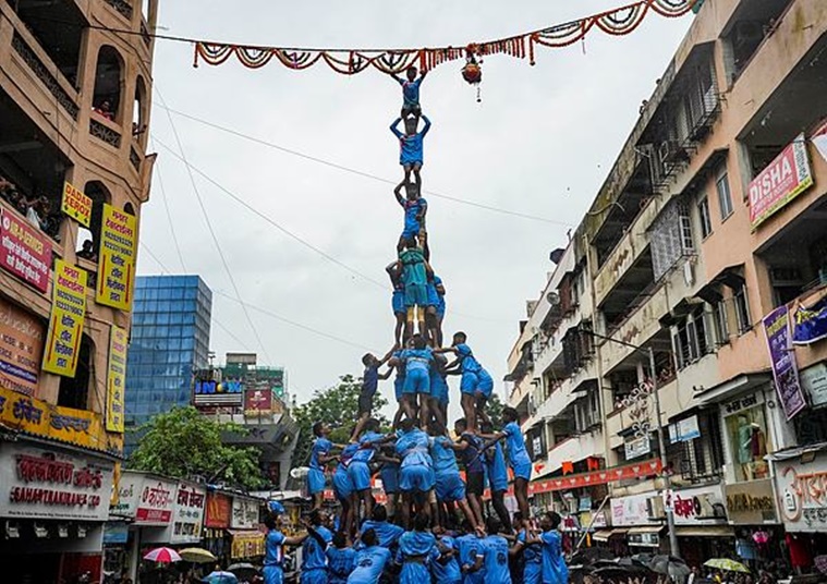 A devotee climbs atop a pyramid formed by fellow devotees to break ‘Dahi Handi’ during the Krishna Janmashtami festival, in Mumbai. (PTI Photo/Kunal Patil)